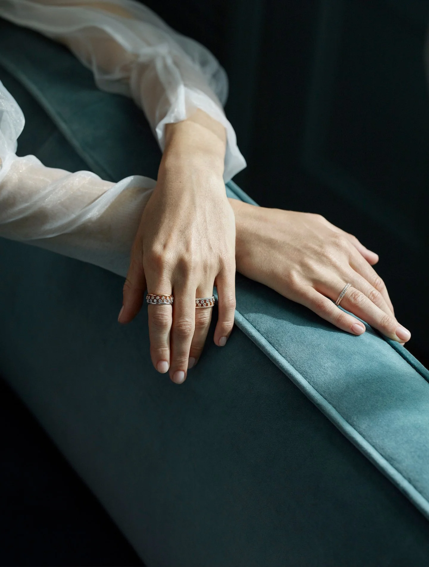Close-up of hands wearing fine jewellery on velvet